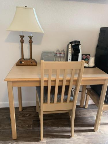 a wooden desk with a lamp and a chair at Cape Motel in Cape Charles
