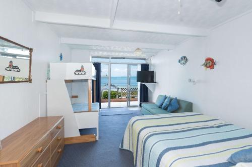 - une chambre avec un lit et une vue sur l'océan dans l'établissement San Marino Motor Lodge Absolute Beachfront, à Coopers Beach