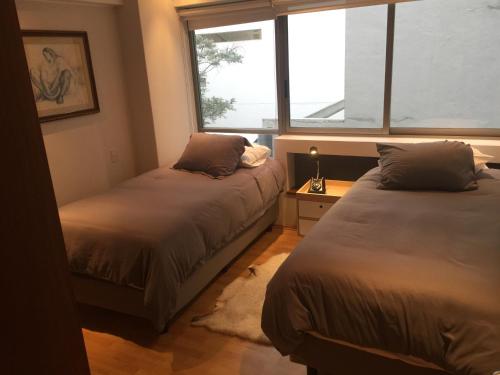 two beds in a room with a window at Best location in Mexico City in Mexico City