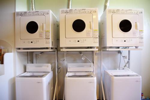 a group of microwaves and washers in a room at K's House Hokkaido - Asahidake Onsen Hostel in Higashikawa