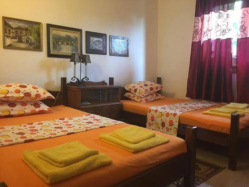 a room with three beds with yellow towels on them at Villa Draganovi in Kamen Bryag