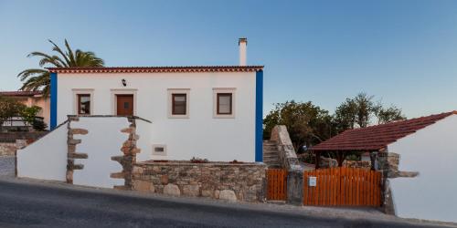 a small white house with a fence in front of it at Casa dos Tios in Fátima