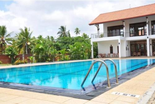 a pool in front of a villa at Villa Agoura Grand Negombo in Negombo