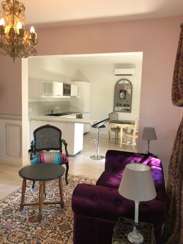 un salon avec un canapé violet et une table dans l'établissement Cottage Parc Duplex of 70 m for 2 people 1 bedroom 2 bathrooms, à Azay-le-Rideau