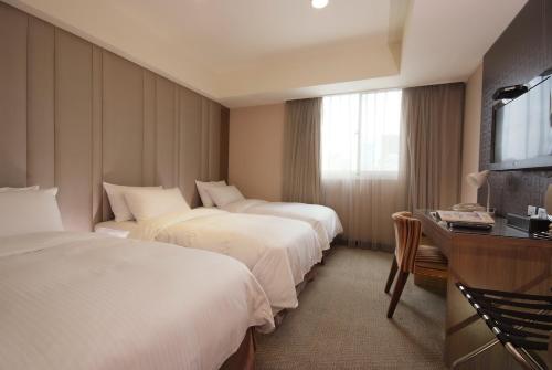 מיטה או מיטות בחדר ב-The Metro Hotel Taichung