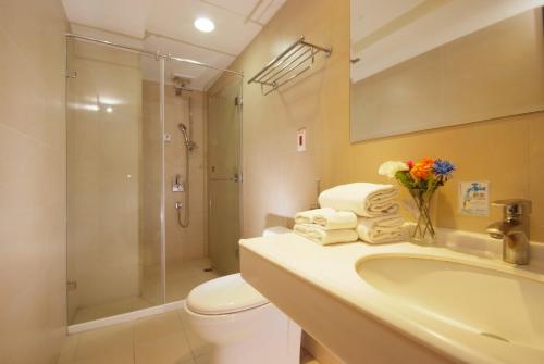 a bathroom with a toilet and a sink and a shower at The Metro Hotel Taichung in Taichung