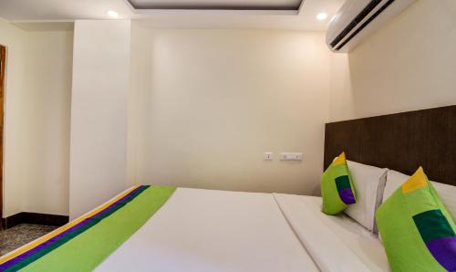 a bedroom with a white bed with colorful pillows at Treebo Sls Grand in Tirupati