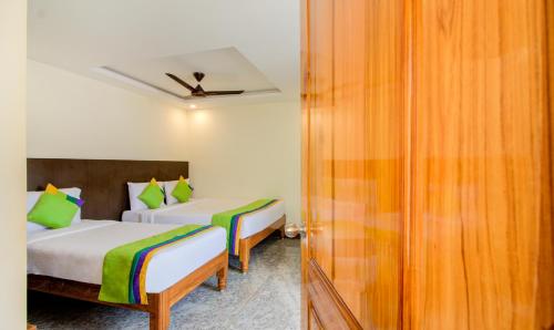 a bedroom with two beds and a door to a room at Treebo Sls Grand in Tirupati