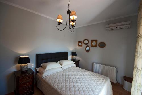 a bedroom with a bed and a chandelier at Anthias Garden in Lefkada Town