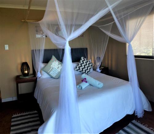1 dormitorio con 1 cama con cortinas azules en Go Wild Resort, en Xai-Xai