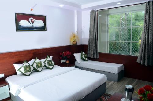 pokój hotelowy z 2 łóżkami i oknem w obiekcie Meera Mahal w mieście Sawai Madhopur