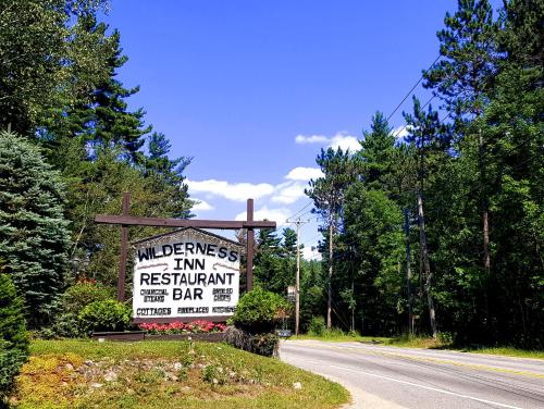 a sign for a restaurant on the side of a road at The Wilderness Inn: Chalets in Wilmington