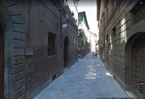 an empty alley with people walking down the street at HostelCiompi in Siena