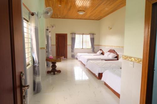 uma sala de estar com duas camas e um sofá em Mondulkiri Holiday homestay em Sen Monorom