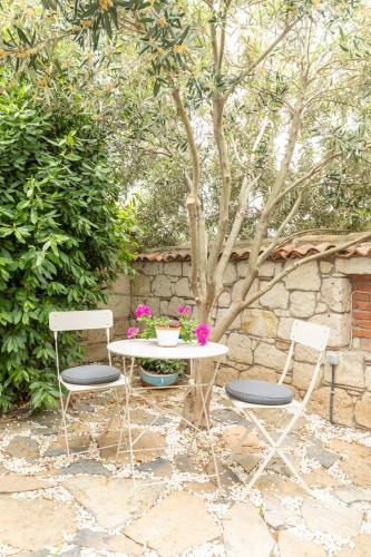 a table with two chairs and a table with flowers at Deniz Kabugu Hotel in Alacati