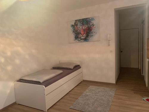 a small bed in a room with a painting on the wall at LINZ bellavista Studio-Apartment Landstraße in Linz