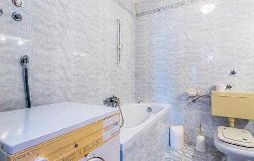 a bathroom with a tub and a toilet and a sink at Apartments SKULIN in Novi Vinodolski