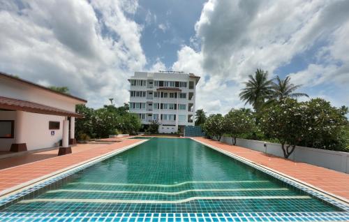 una piscina di fronte a un edificio di Khanom Sea Breeze apartment a Khanom