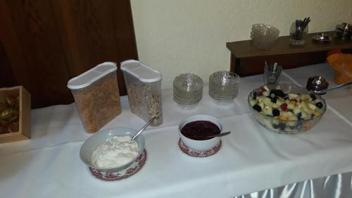 a table with two bowls of food and a bowl of fruit at Pottensteiner Stuben Pension Gasthof in Pottenstein