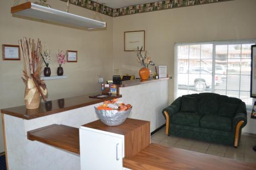 a living room with a green couch and a table at Gateway Inn Fairfield in Fairfield