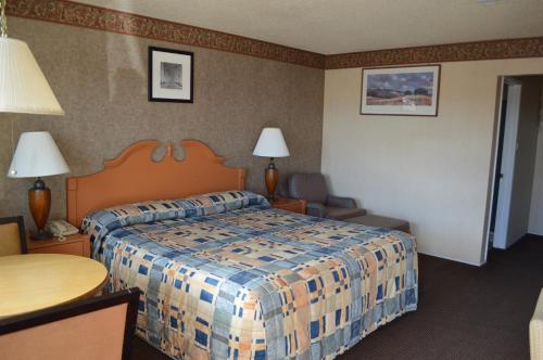 a hotel room with a bed and a table at Gateway Inn Fairfield in Fairfield