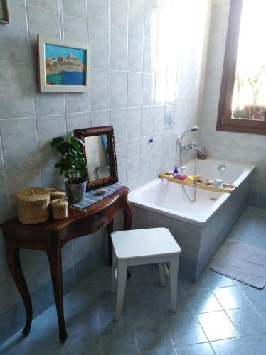 a bathroom with a tub and a table and a mirror at Great apartament in Feltre in Feltre