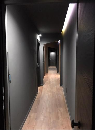 a hallway with a long corridor with doors and wooden floors at Residenza del Castillo in Palermo