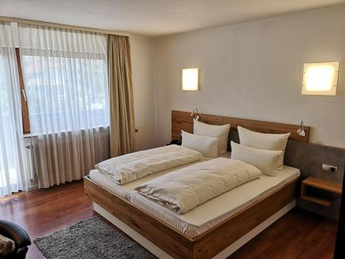ein Schlafzimmer mit einem großen Bett mit weißen Kissen in der Unterkunft Landhotel Rebstock in Oberkirch