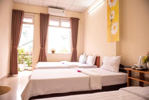 順化的住宿－明丹旅館，带2扇窗户的客房内的2张床