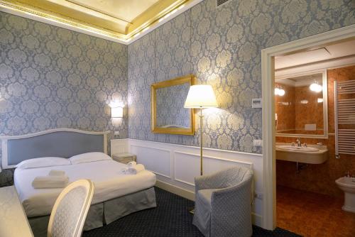um quarto de hotel com uma cama e uma casa de banho em Corte Barozzi Venice Suites em Veneza
