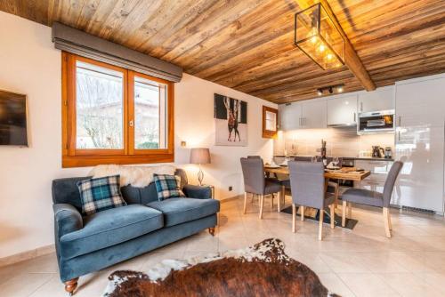 un salon avec un canapé bleu et une cuisine dans l'établissement JEANETTE 4, à Morzine