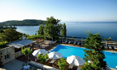 a view of a pool with umbrellas and the water at Atrium Hotel in Agia Paraskevi