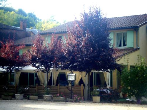 a house with two trees in front of it at Hôtel Auberge de La Nauze in Sagelat