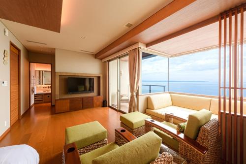 a living room with a couch and a large window at AMANE resort SEIKAI in Beppu