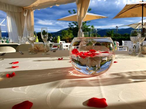 Magliano deʼ MarsiにあるAgriturismo Il Timoの赤い花のテーブルの上にガラス鉢をかけたテーブル