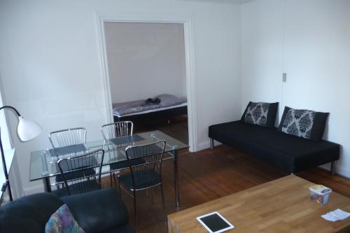 a living room with a glass table and a couch at Stor lejlighed midt i Sønderborg by. in Sønderborg