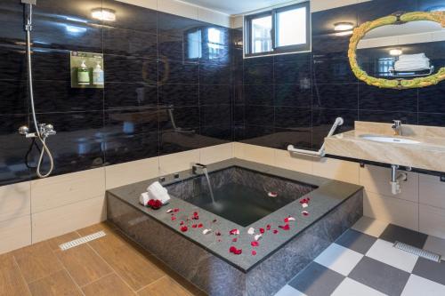 a bathroom with a bath tub with red roses in it at 埔里夏都華蔓山林日式會館 Puli Huaman Villa in Puli