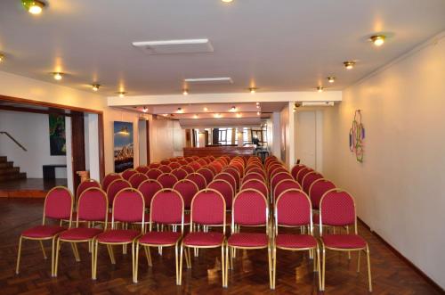 a room with a row of red chairs in it at Hotel Colonial Salta in Salta