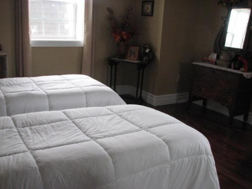 a bedroom with a white bed and a window at Argyle By The Sea Bed & Breakfast in Pubnico