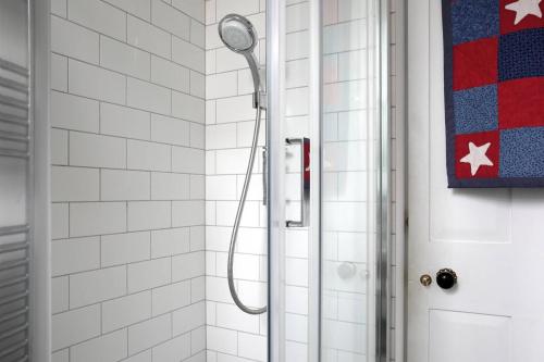 une douche avec une pomme de douche à côté d'une porte dans l'établissement 5 star beautiful & vintage, spacious apt in chic location!, à Édimbourg