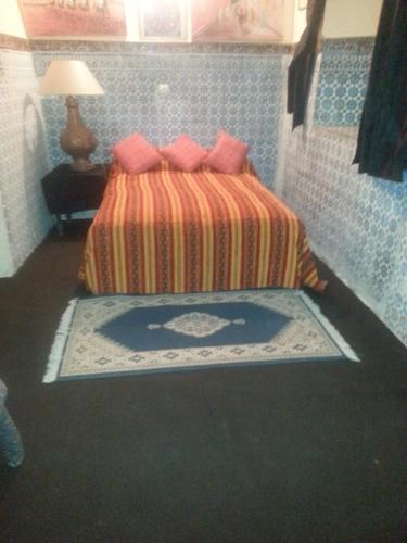 ein Schlafzimmer mit einem Bett mit rosa Kissen in der Unterkunft RIAD DAR KADER chambre saumon in Marrakesch