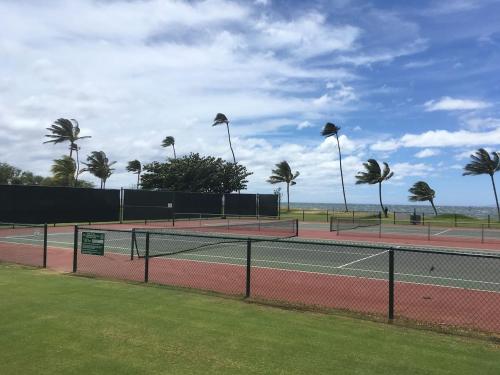 two tennis courts with palm trees and the ocean at Perfect for families and couples - Maui Sunset A-203 in Kihei