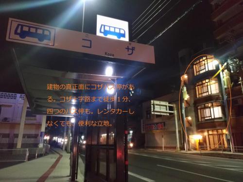 a sign for a bus stop on a street at night at Guesthome Machiya Koza in Okinawa City