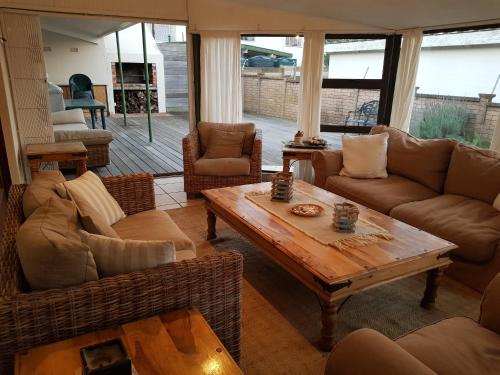a living room with couches and a wooden table at Bushys Oak in Bushmans River Village