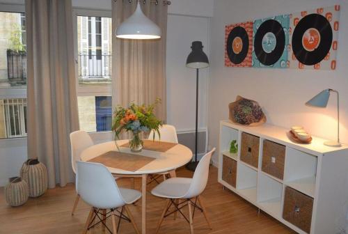 a dining room with a table and white chairs at Burdigala Homes - Appart de Lalande in Bordeaux