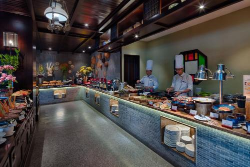 two chefs are preparing food in a kitchen at Little Riverside Hoi An . A Luxury Hotel & Spa in Hoi An