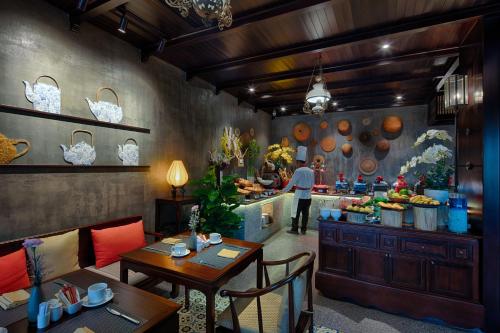 a restaurant with tables and a chef preparing food at Little Riverside Hoi An . A Luxury Hotel & Spa in Hoi An