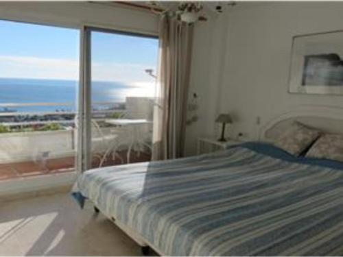 una camera con un letto e una grande finestra di Sea View Penthouse Duplex near Beach a Mijas Costa
