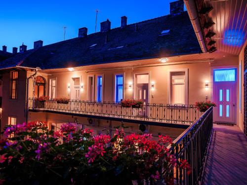 ein Gebäude mit einem Balkon mit Blumen davor in der Unterkunft Luxury Smart Apartments in Szeged