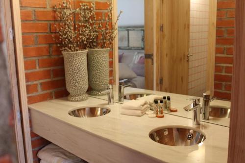 uma casa de banho com 2 lavatórios e um espelho em La Holandesa em Cercedilla